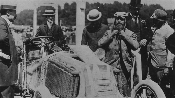 A Black and White photo of people standing near the driver