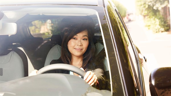 A women is smiling while driving