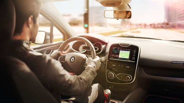 A man driving a Renault car in the city